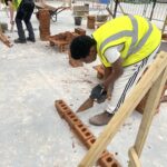 Bricklaying learners building a wall